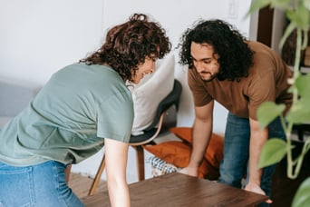 Two people lifting table