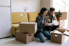 Two people packing objects in boxes