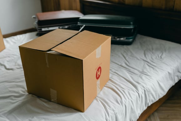 Box on bed with suitcase