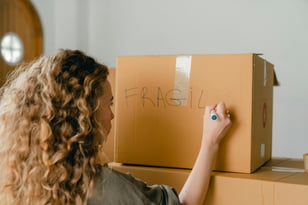 Woman labelling box as fragile