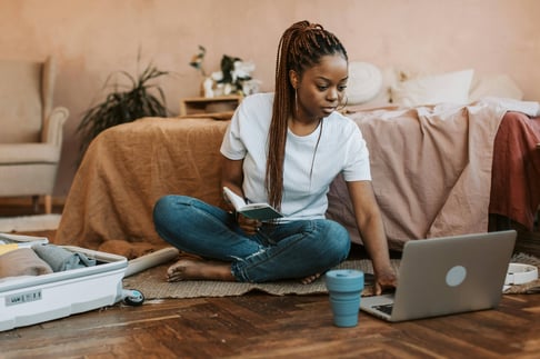 Woman sitting on floor packing 